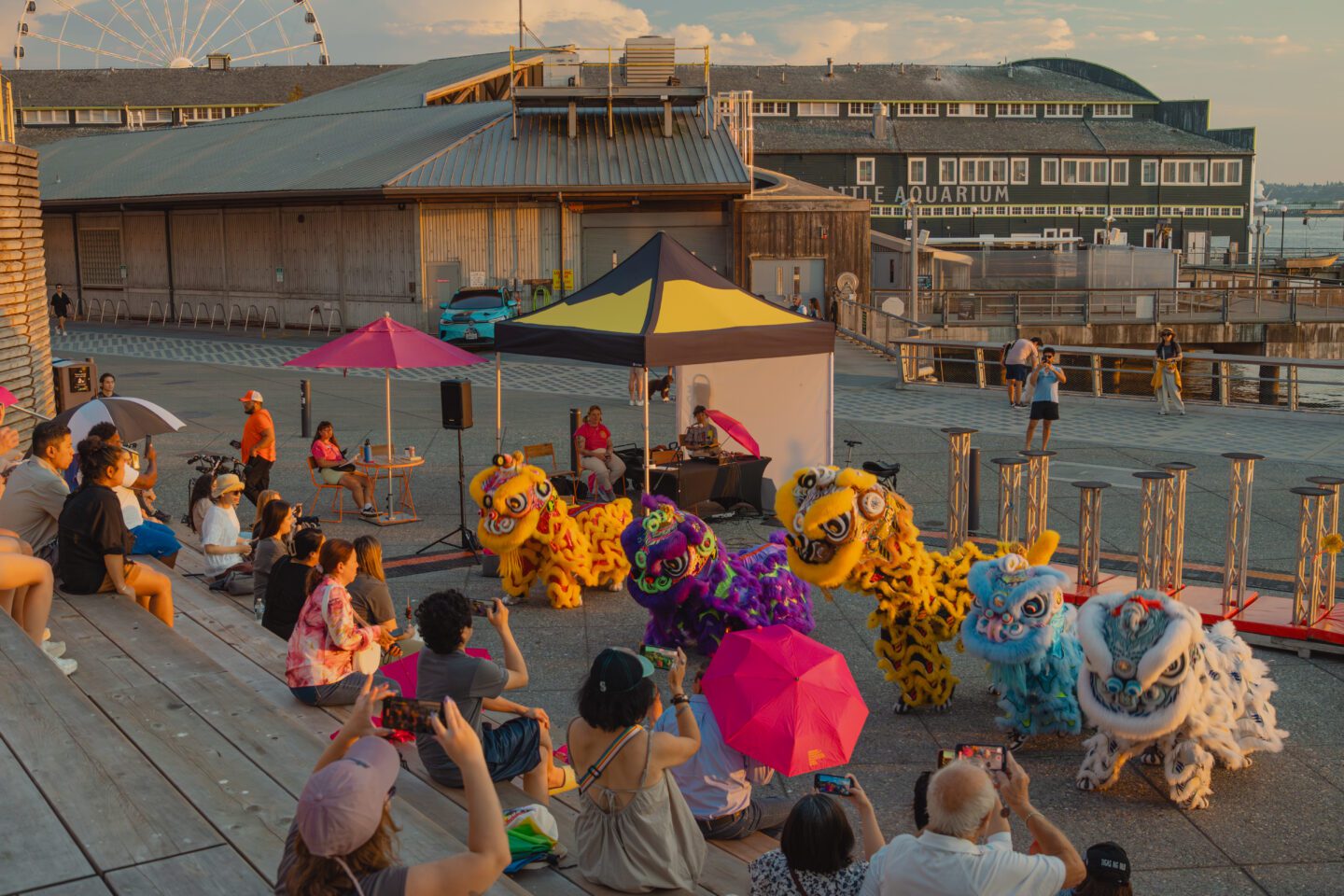People sitting on a pier watching a performance.