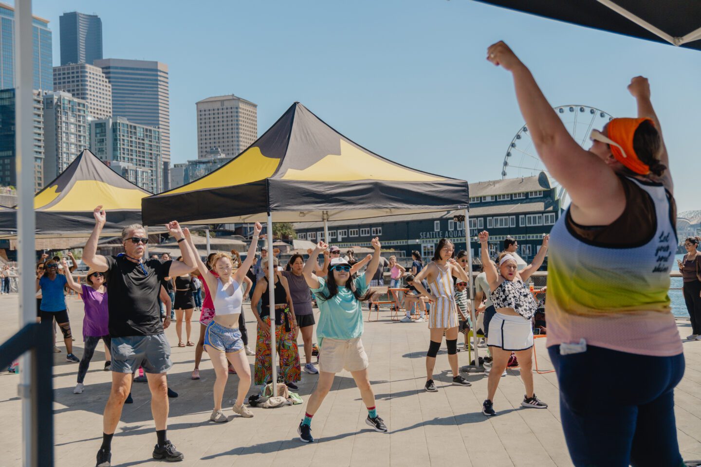 A group of people with their hands up facing an instructor.