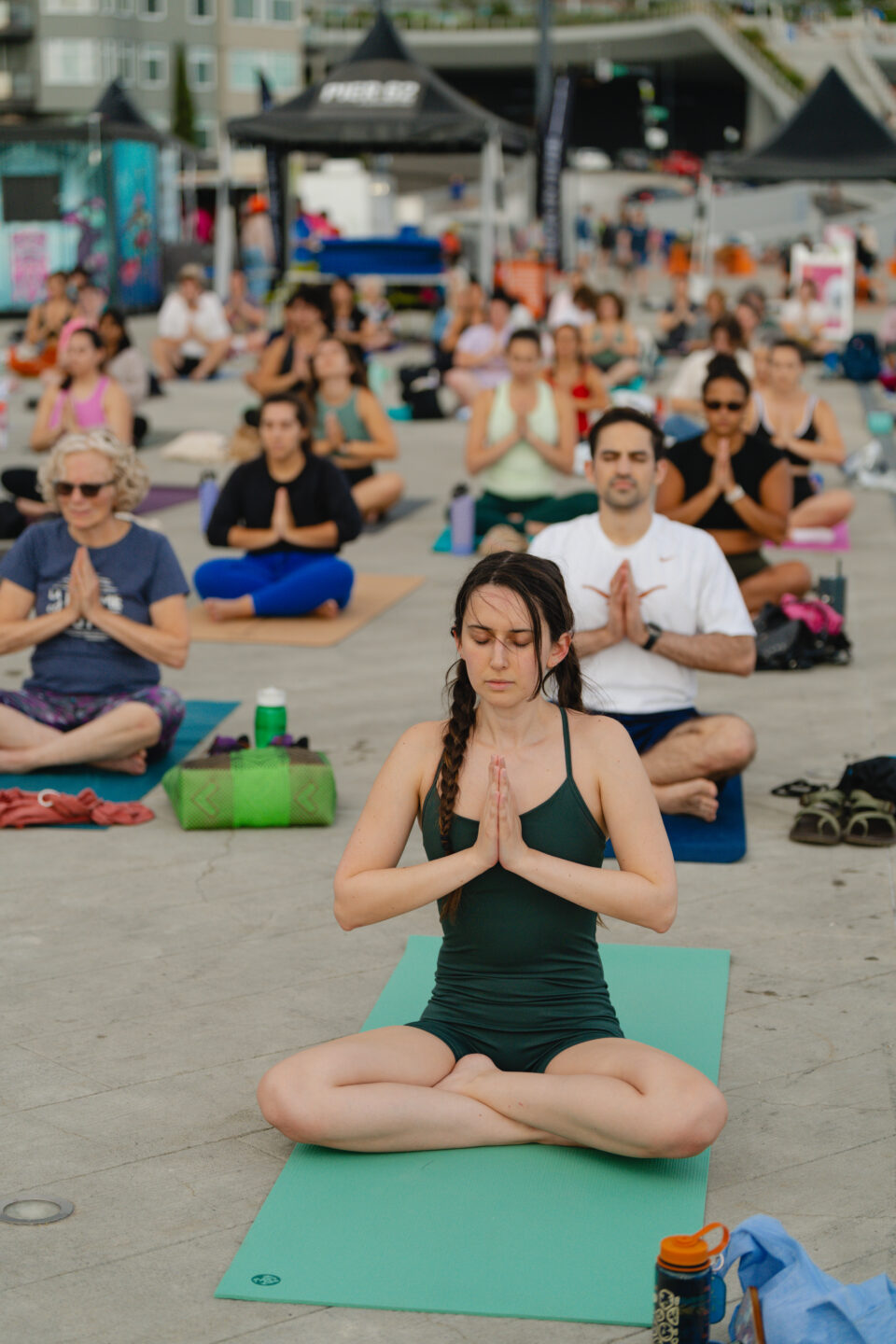 A group of people sitting on yoga mats with their legs crossed.
