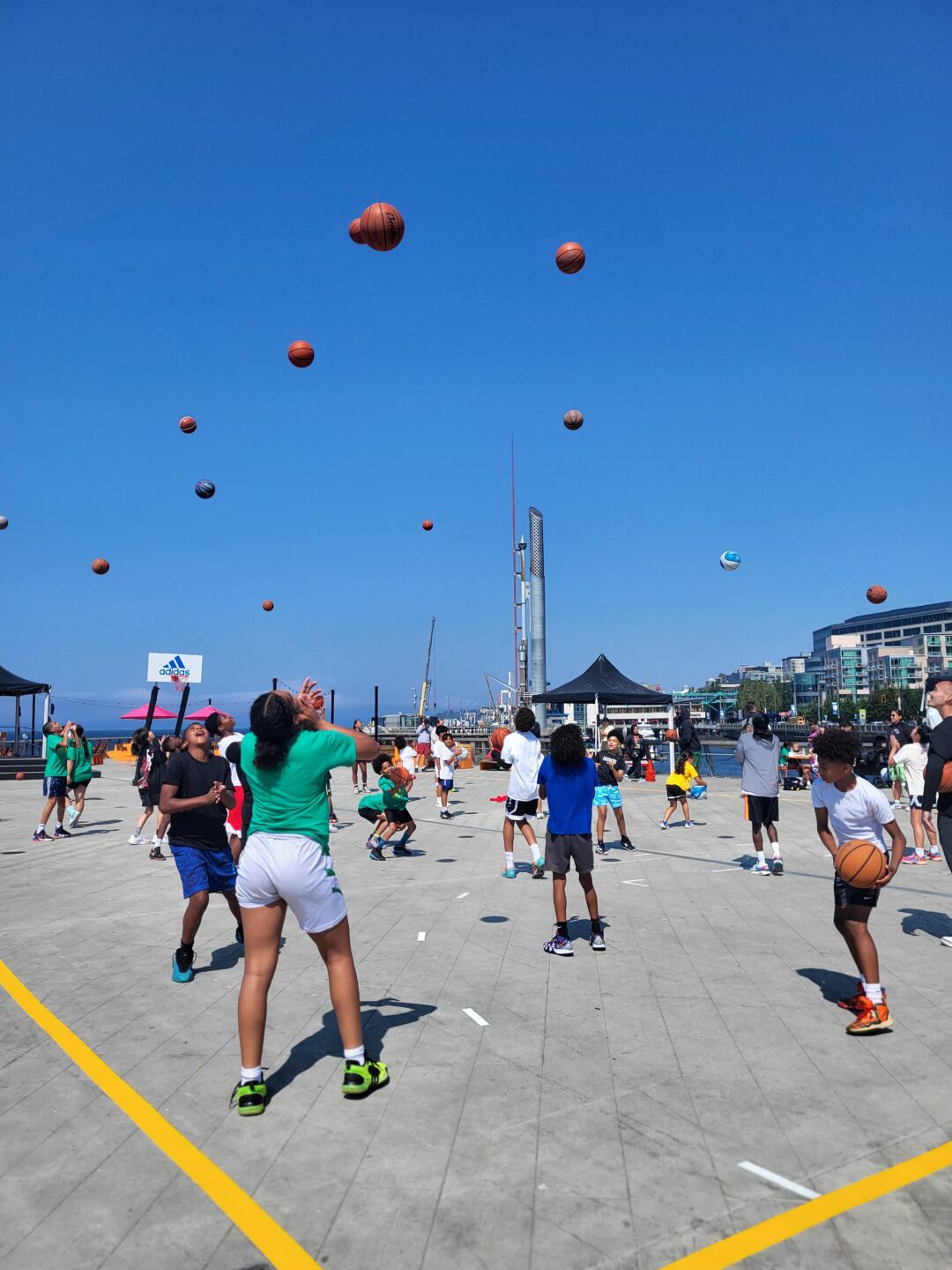 Kids learning basketball skills on Pier 62 during Hoops on the Pier event.