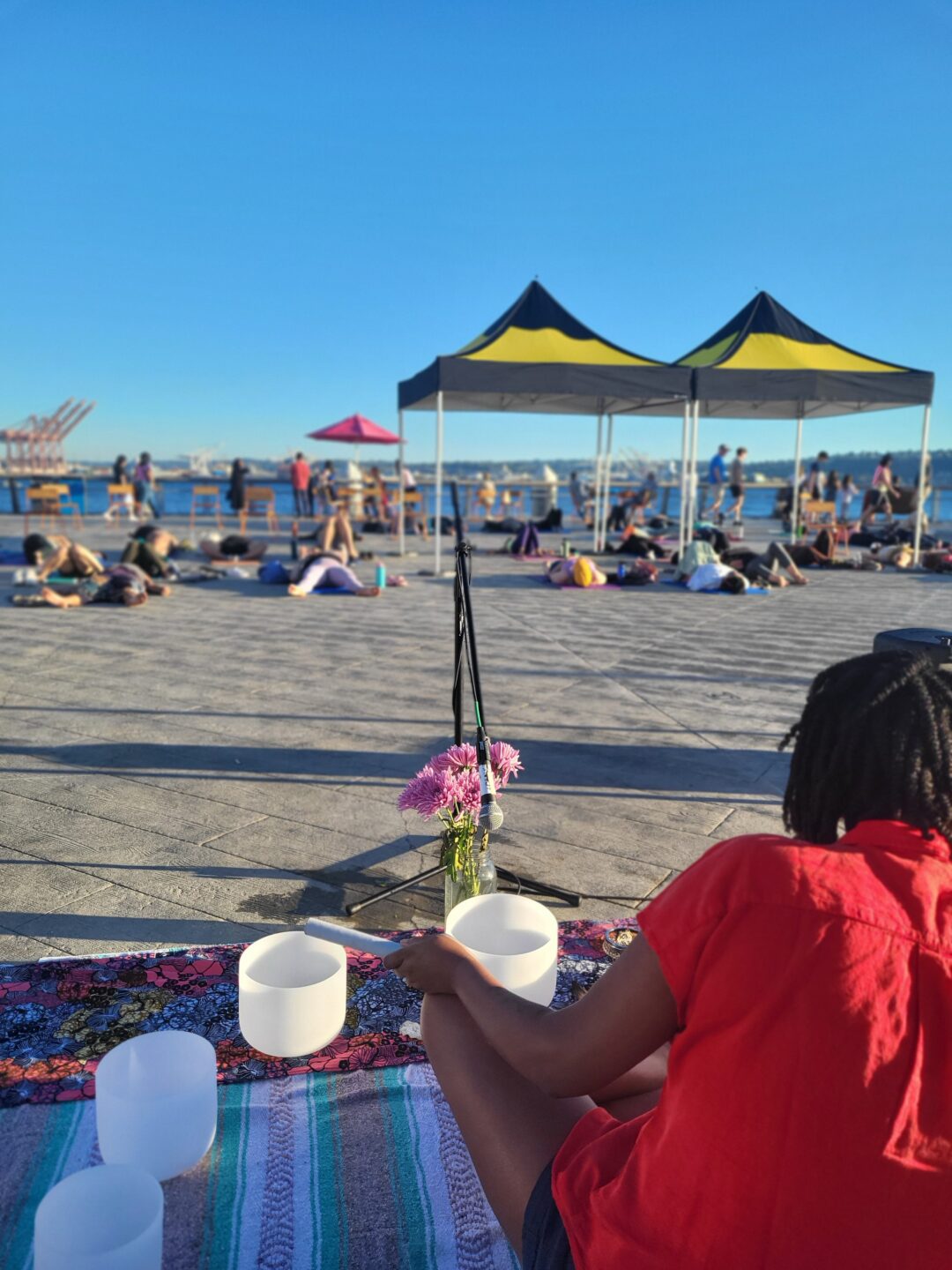 Visitors enjoying a group sound bath meditation on Pier 62.