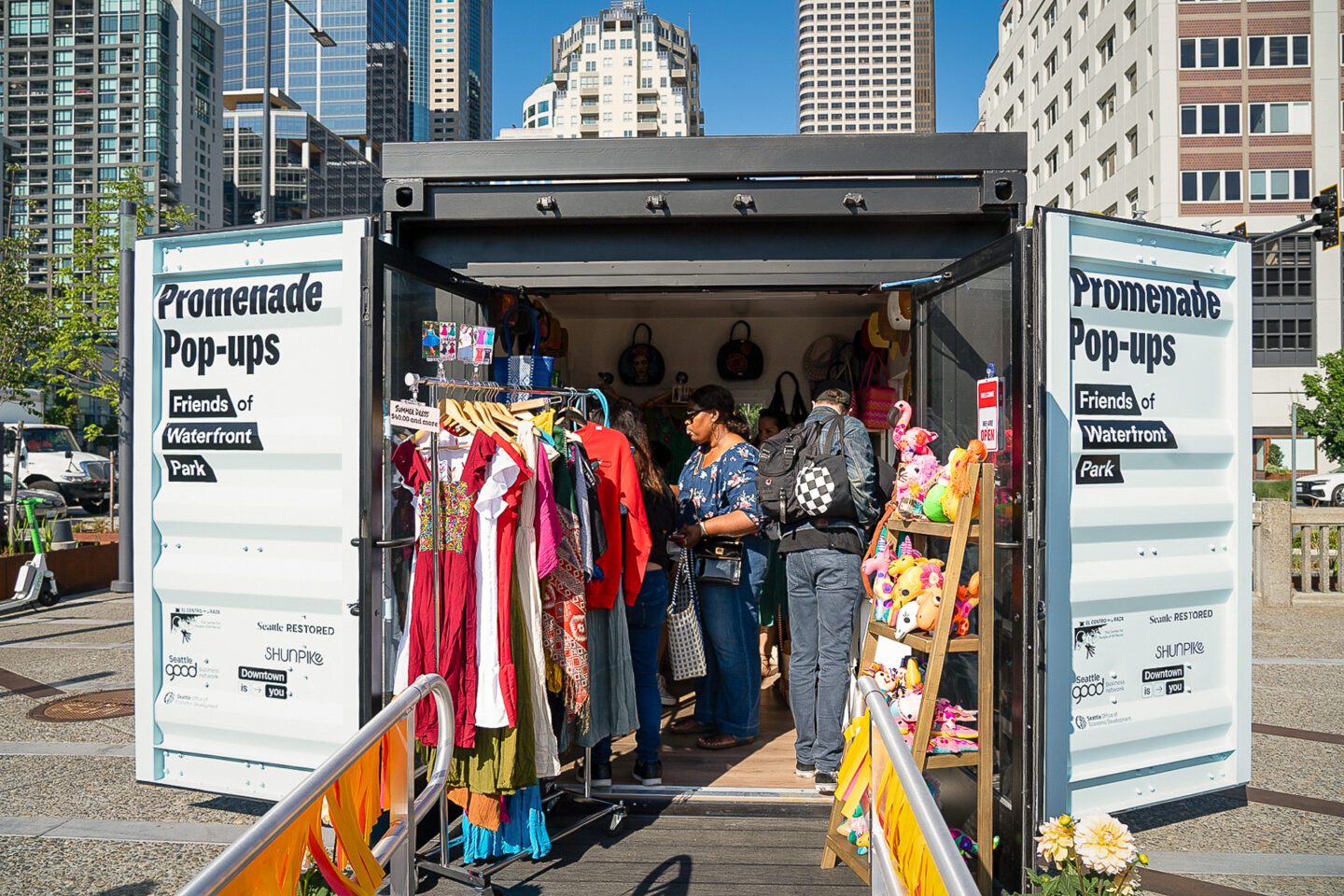 Two people shop inside of a Promenade Pop-up kiosk