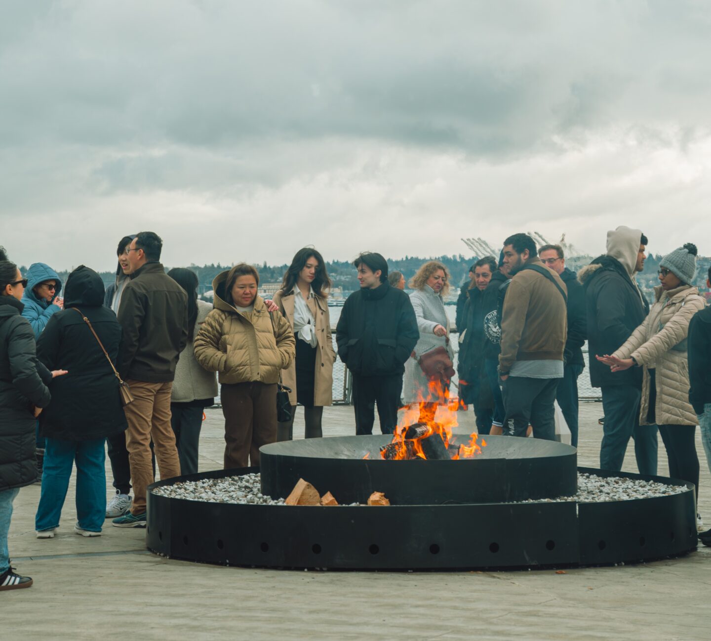 People gathered around a wood burning fire on Pier 62.