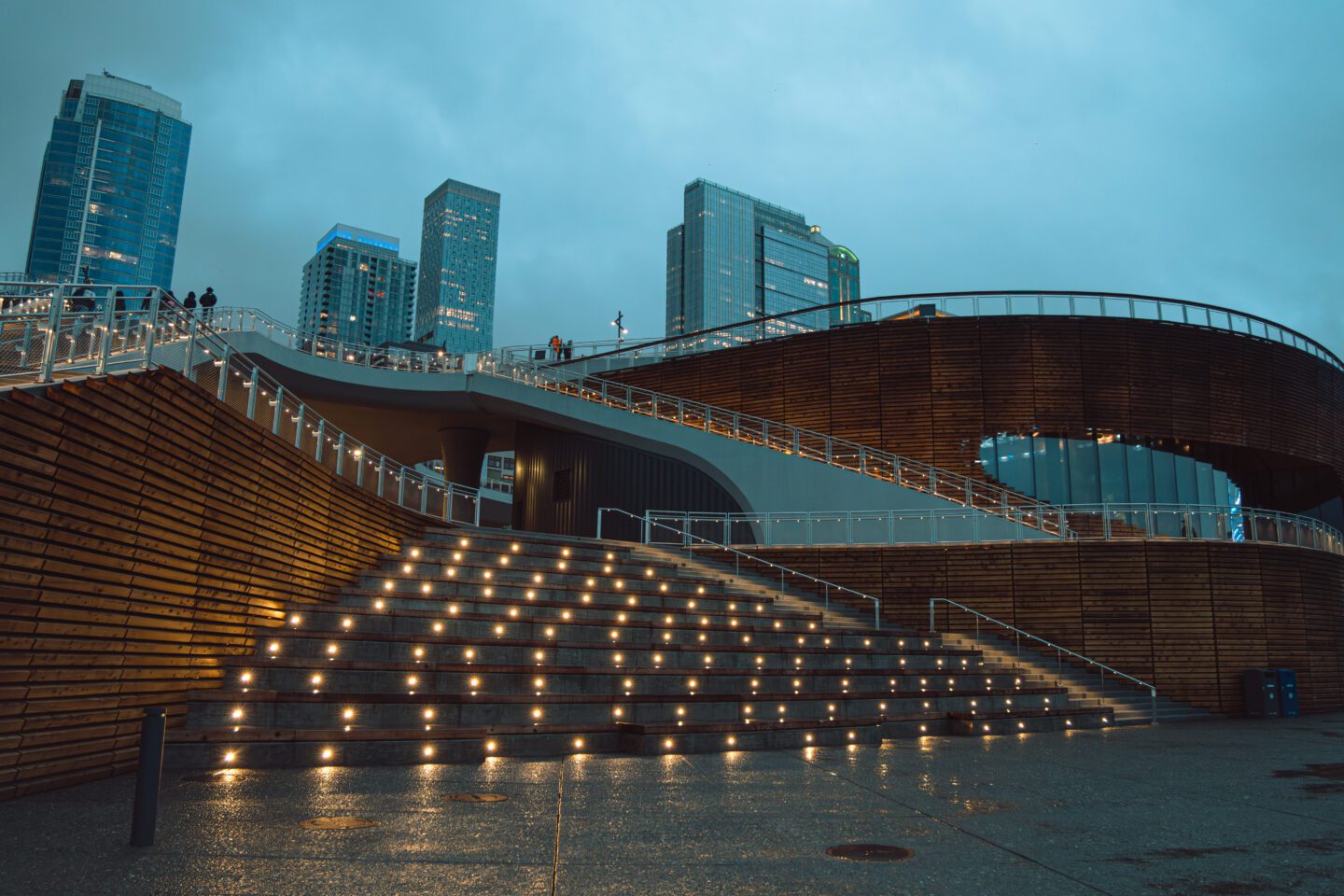 Rainy evening with built in lights illuminating the Salish Steps and Overlook Walk pathways.