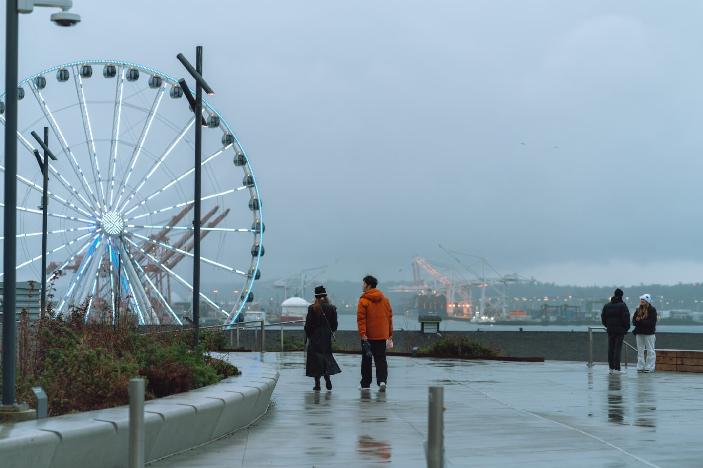 A rainy day at Overlook Walk with people strolling towards the Great Wheel.