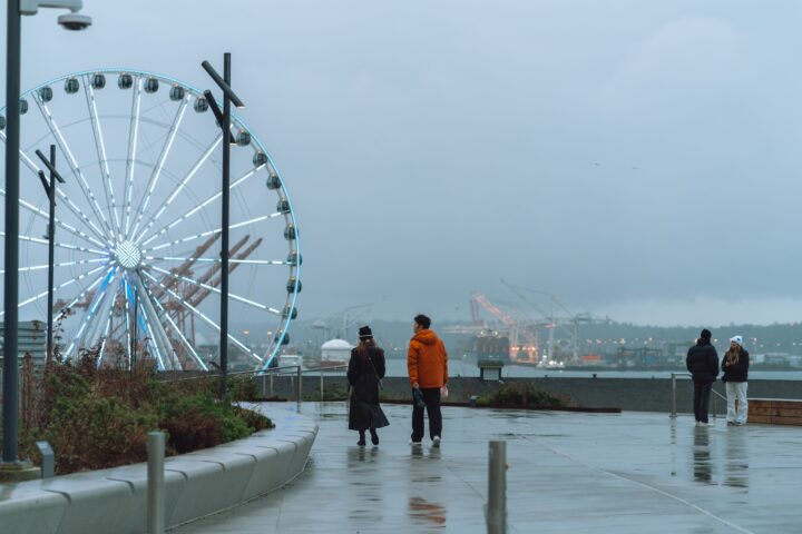 A rainy day at Overlook Walk with people strolling towards the Great Wheel.