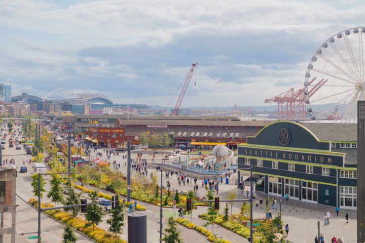 Aerial view of Seattle's waterfront looking south, showing the Park Promenade, Seattle Aquarium, Great Wheel and Lumen Field in the distance