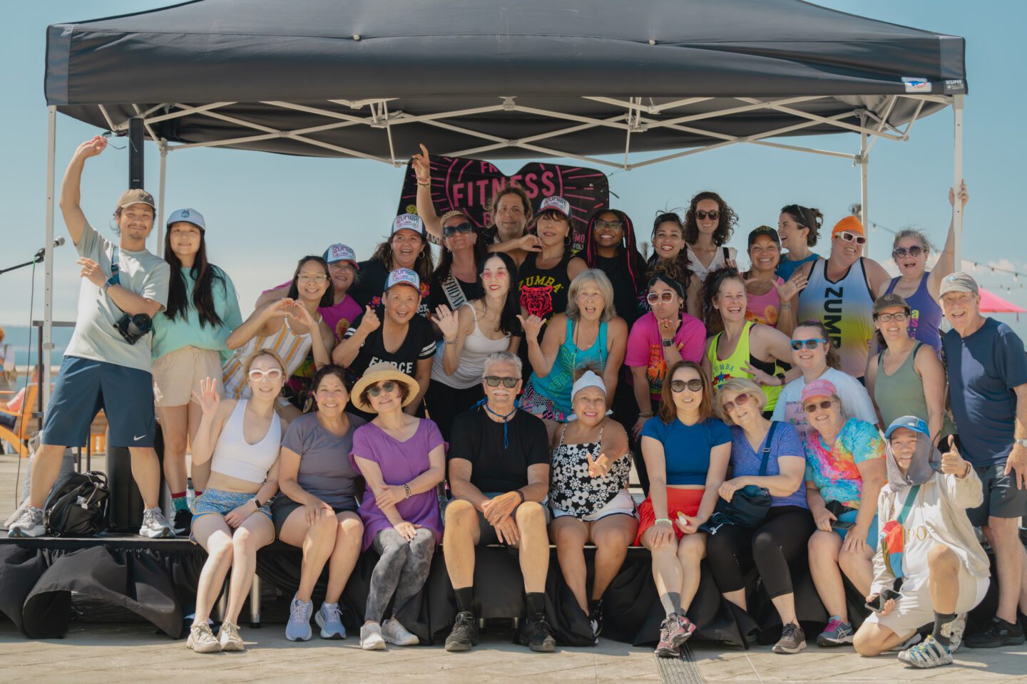 A group of people posing together under a black tent.