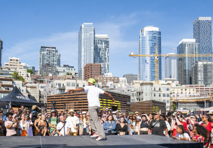 A Hip Hop 50 performer on stage with a crowd of people watching.