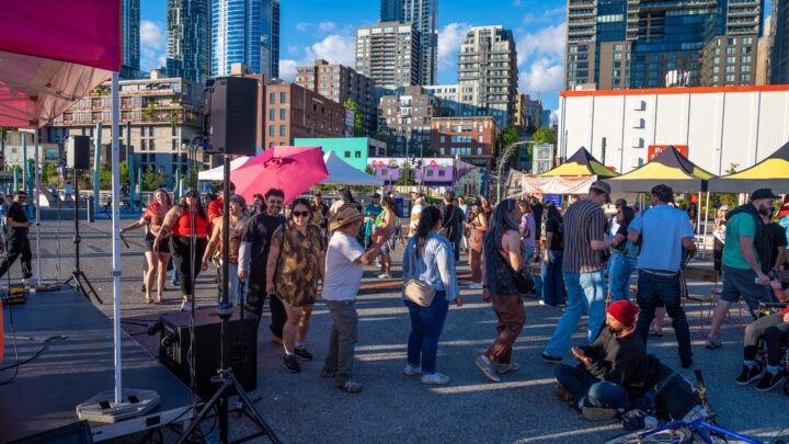 A large group of people walking in a circle at an outdoor city event.
